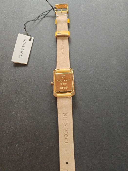 Ceas de dama Nina Ricci  auriu cu cadran alb original, nou  fără cutie