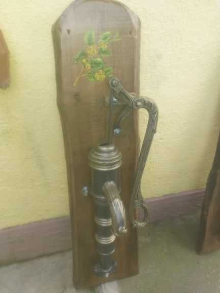 Fantana arteziana din fonta asezata pe un suport de lemn pictata