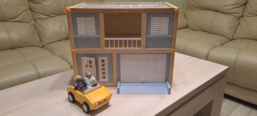 Нова дървена къща с кола и два фигурки