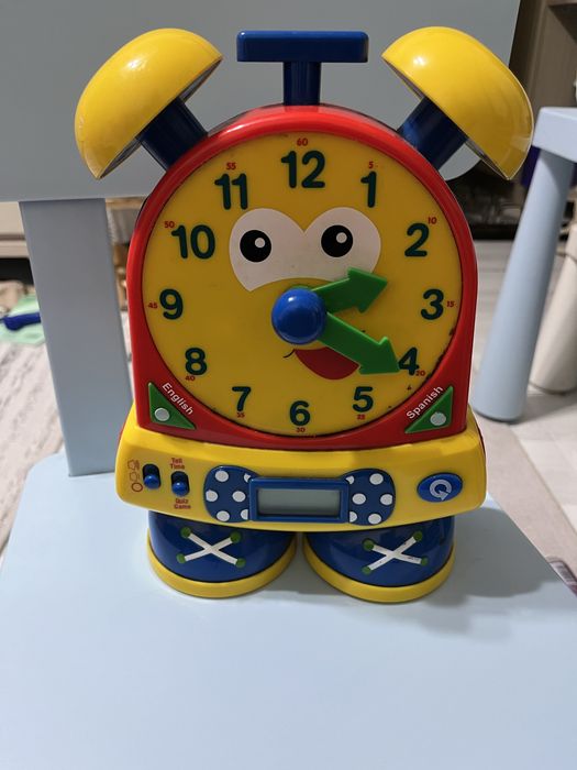 Часы учат ребенка времени на русском и испанском языке
