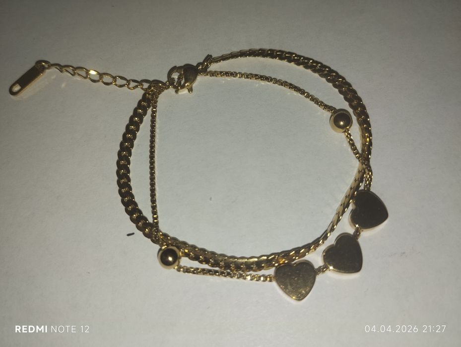 Золотистый браслет из двух цепей с сердцами.