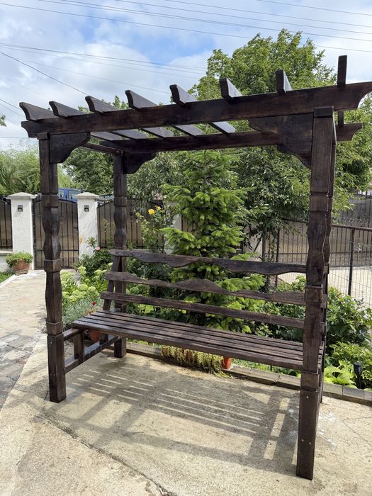 Pergolă rustică cu bancă integrată.