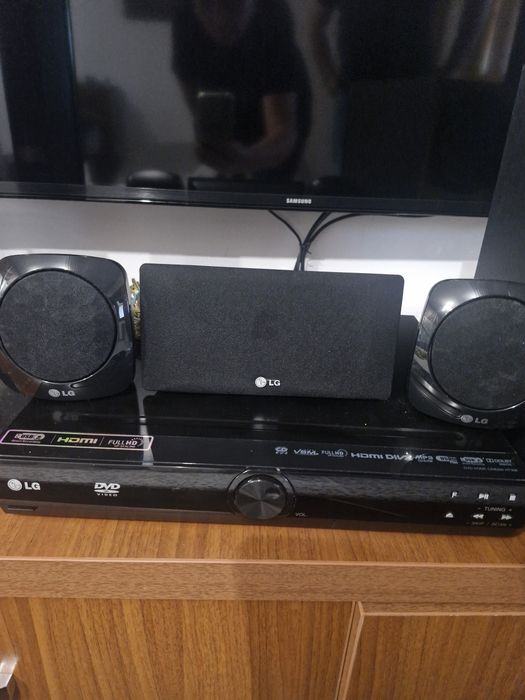 SIstem Home Cinema LG 5.1 compus din boxe verticale de tip tallboy, un subwoofer, o boxă centrală, două boxe satelit mici poziționate pe unitate