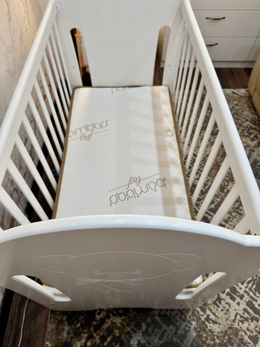 Люлеещо дървено легло с матрак и чекмеджета за съхранение.