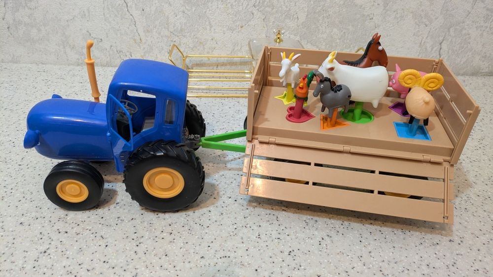 Синий трактор с прицепом и животными