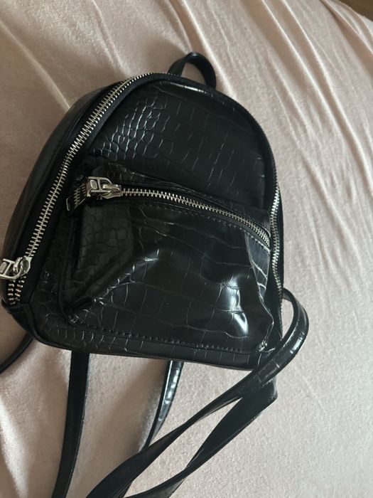 Черна, кажена раница с регулируеми презрамки.