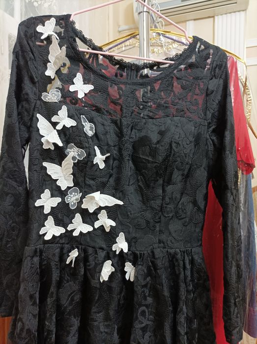 Qora ko'ylak oldi qismiga kapalekla bilan ishlov berilgan