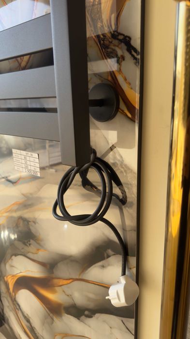 Полотенцесушитель с полочкой от производителя черного цвета.