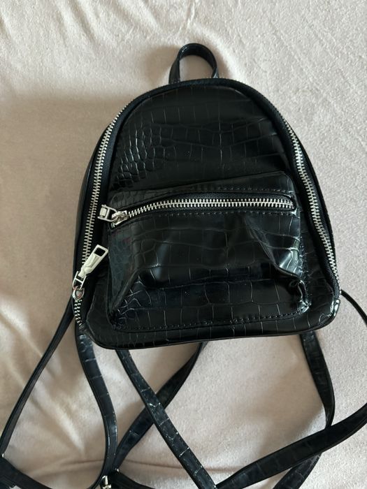 Черна, кажена раница с регулируеми презрамки.