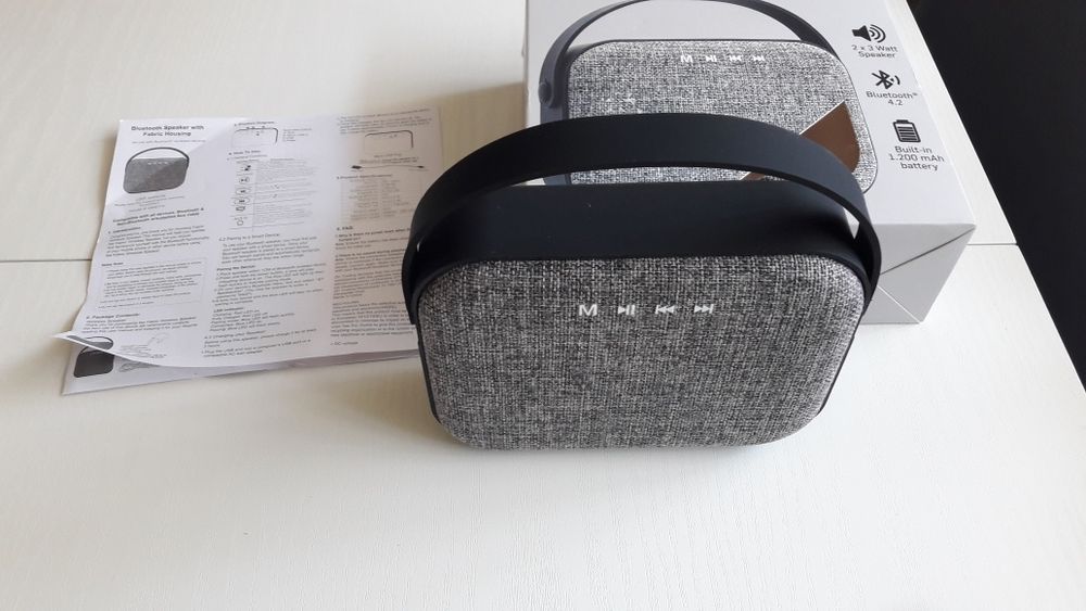 Блутут колонка говорител с текстилна обвивка и гумирана дръжка.