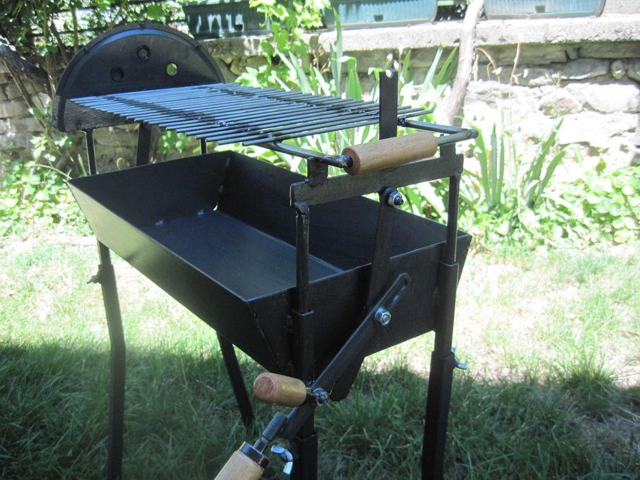 Барбекю на дървени въглища с въртящи се шишове и скара.