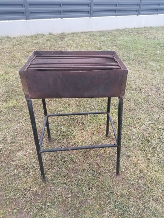 Grătar de inox, picioare de fier, 45x31 cm. 
Are lipsa o bara din gril
