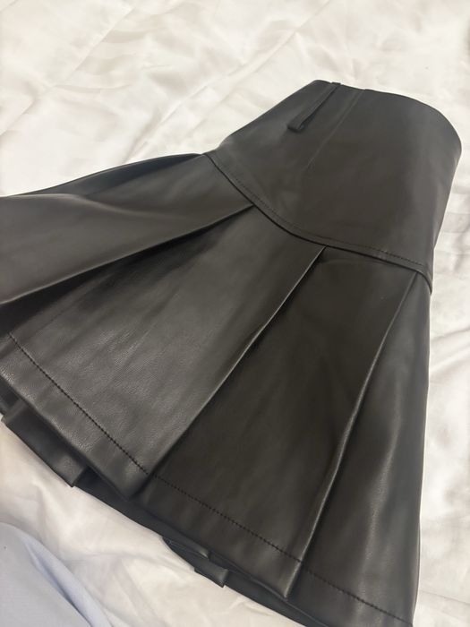 Fustă neagră scurtă din piele cu pantaloni pe dedesubt