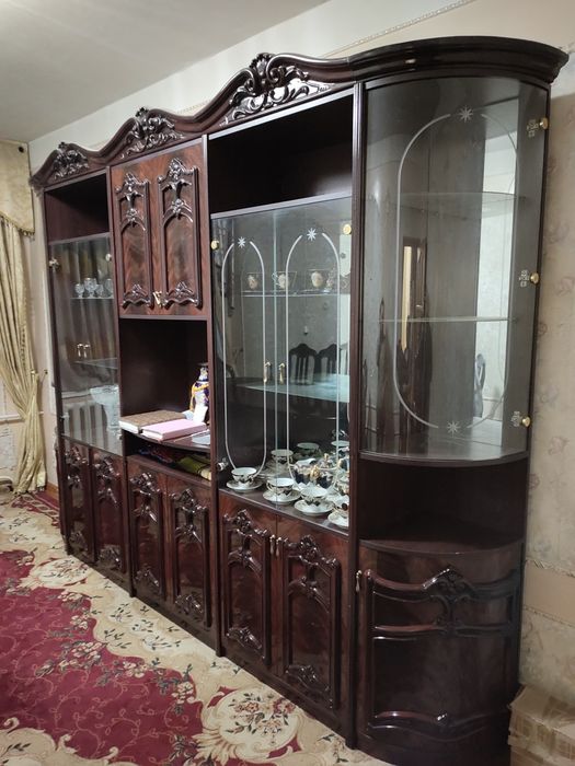 Стенка и стол стулья.