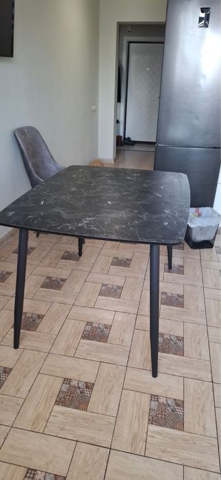 Стол кухонный с черной столешницей под мрамор.