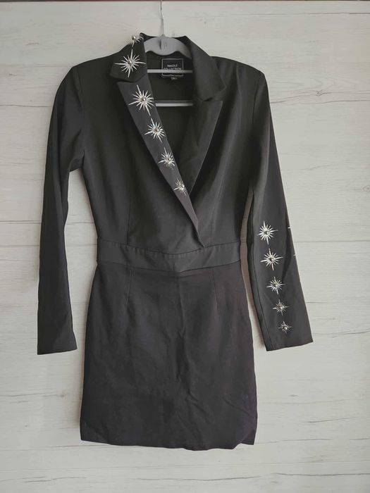 Елегантна черна рокля с декоративни елементи.