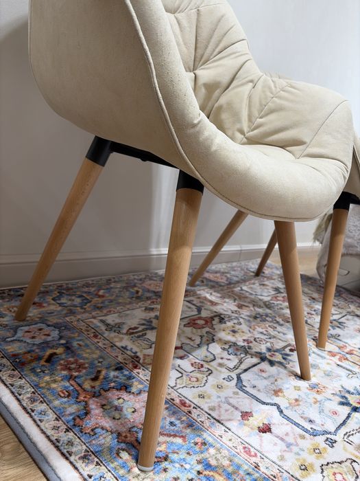 Кресло, обитое тканью, с ножками из натурального дерева.