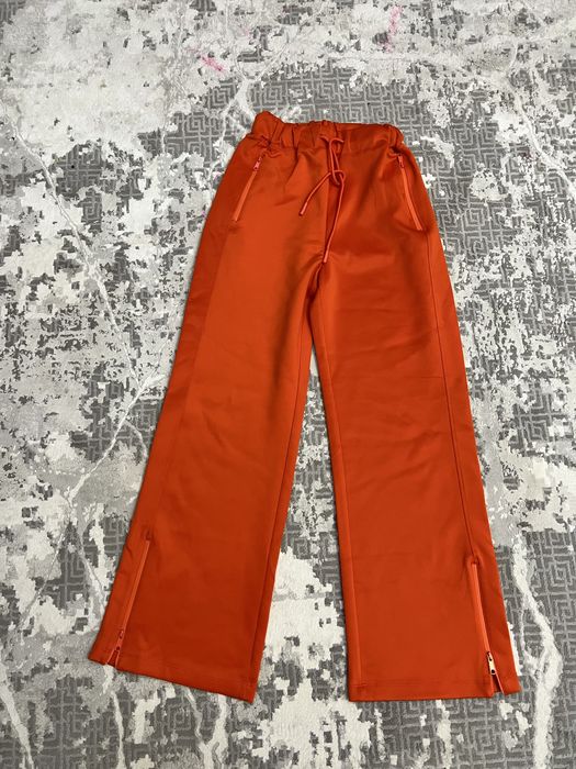 Яркие спортивные штаны оранжевого цвета.