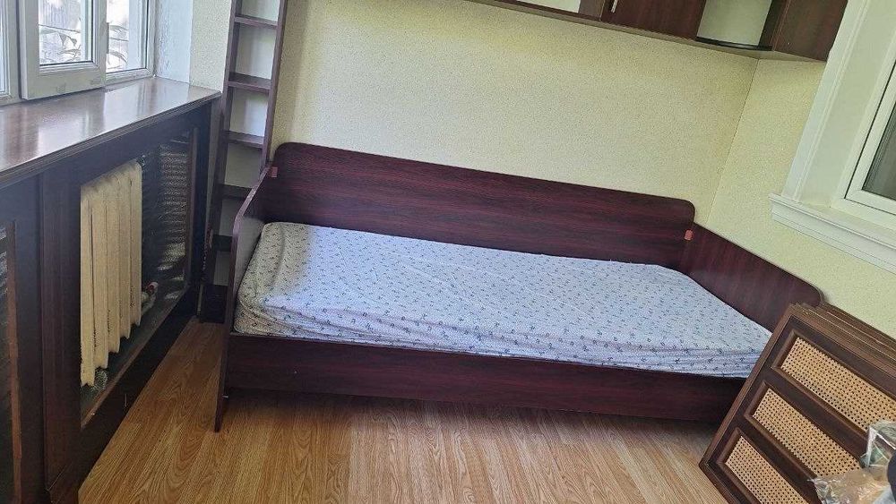 Ortopedik matras va saqlash javoniga ega karavot.