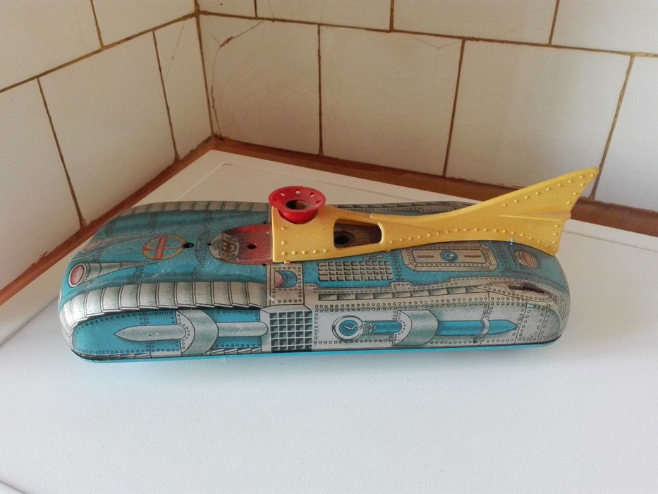 Две стари картини графика , пластмасови животни и ламаринен луноход .