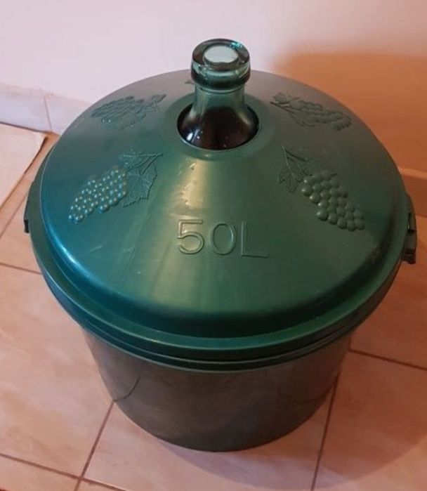 Vand 2 damigene , în cos de plastic  de 50 l,