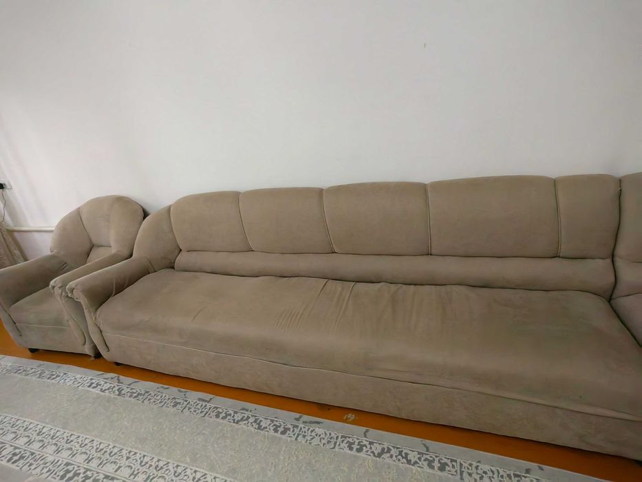 Диван уголок, два кресла и книжный шкаф.