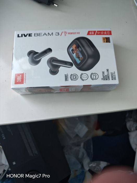Безжичните слушалки JBL Live Beam 3. Това са премиум True Wireless слушалки (тип „тапи“),