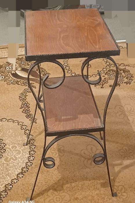 Това е помощна маса в индустриален стил с две нива и метална рамка.