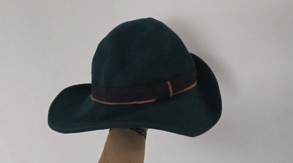 Зимна вълнена тъмно зелена дамска шапка.