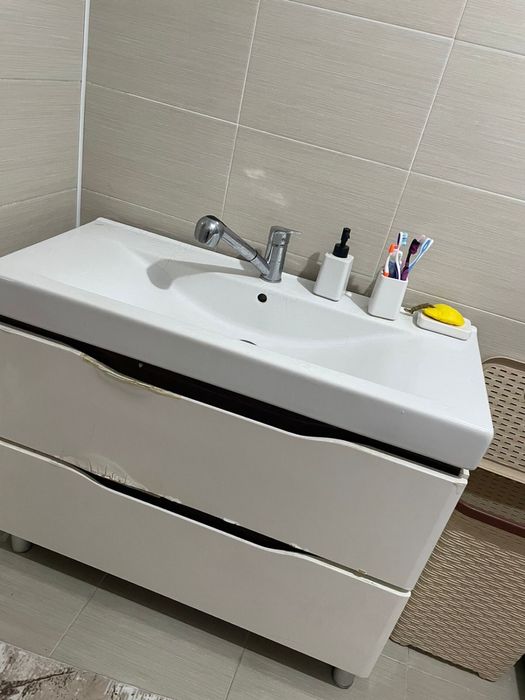 Раковина белого цвета с двумя шкафами