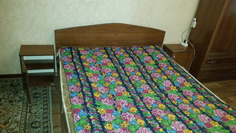 Двухспальная кровать с тумбочками.