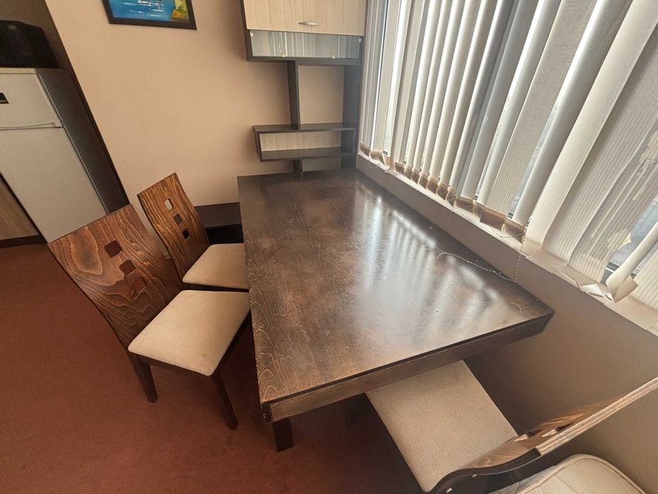 Кухненско обзавеждане с мивка и смесител, маса с три стола и секция