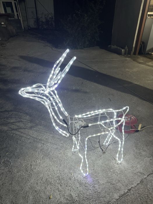 Новогодние украшения в форме оленей и гирлянды.