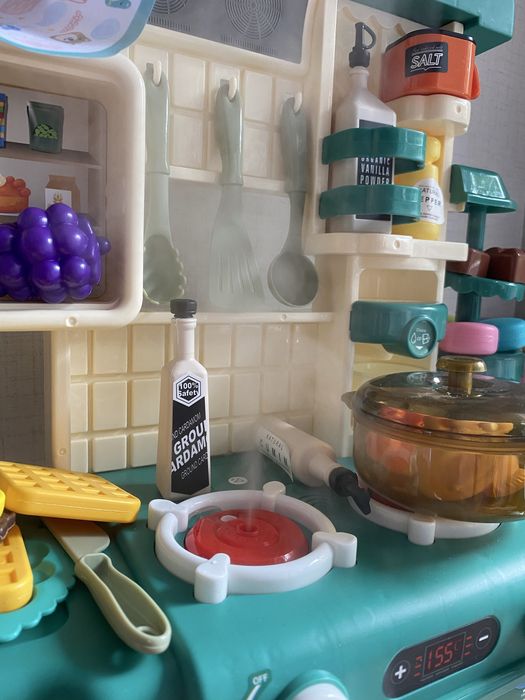 Кухня със светещи котлони, пара и мивка с течаща вода