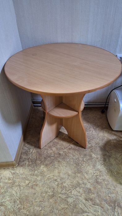 Круглый стол из прочного ламинированного ДСП в светлом дереве.