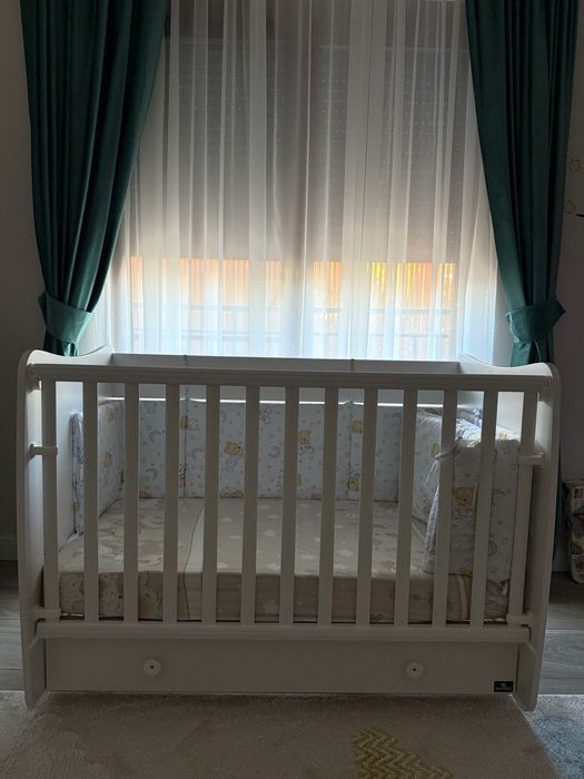 Vând pătuț alb din lemn cu sistem de legănare