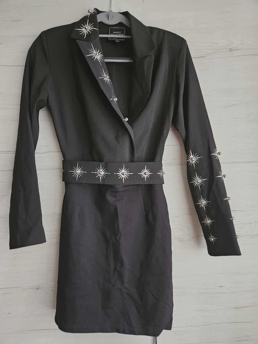 Елегантна черна рокля с декоративни елементи.