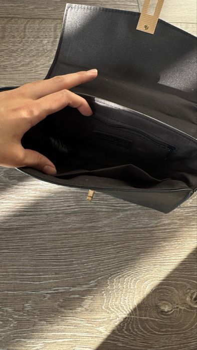 Маленькая чёрная вечерняя сумка с золотистой фурнитурой.