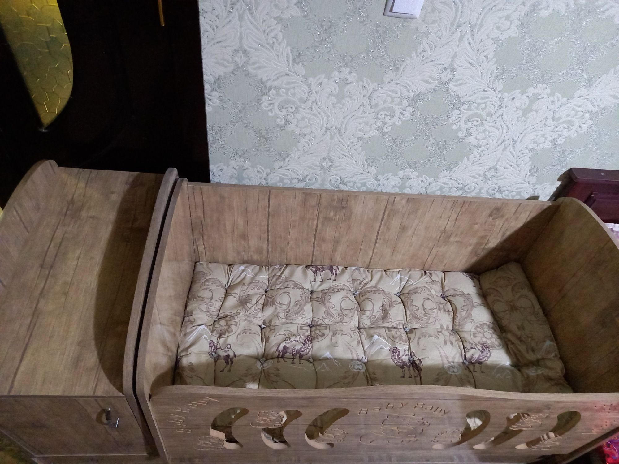 Детская кроватка с шкафчиком, двумя раздвижными ящиками и матрасом.