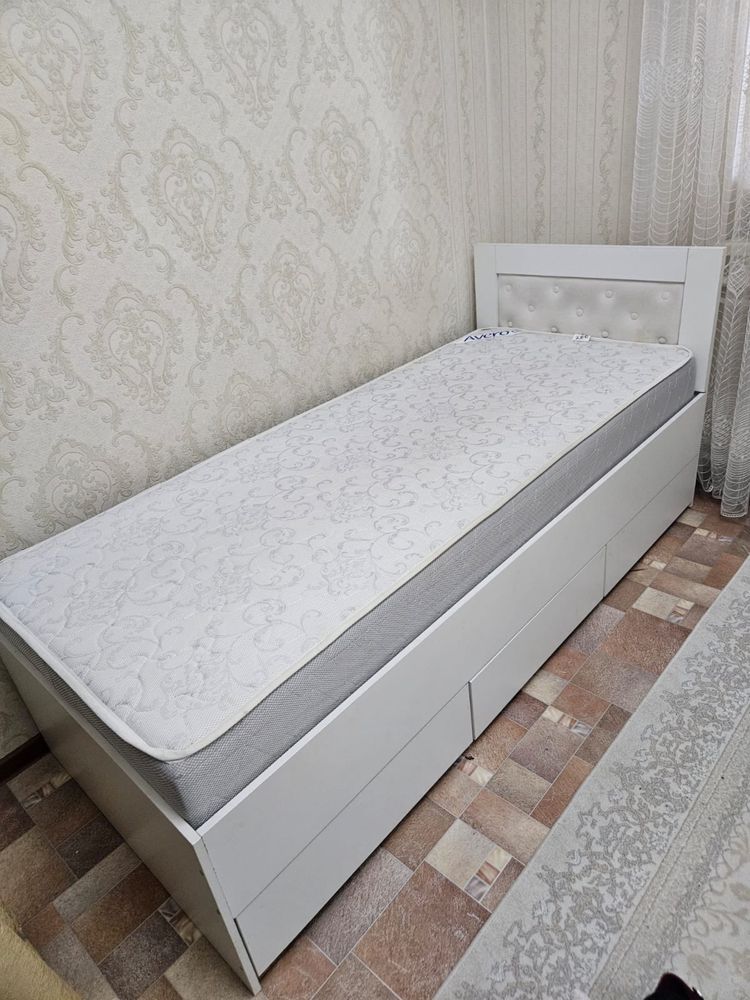 Кровать и стол письменный.