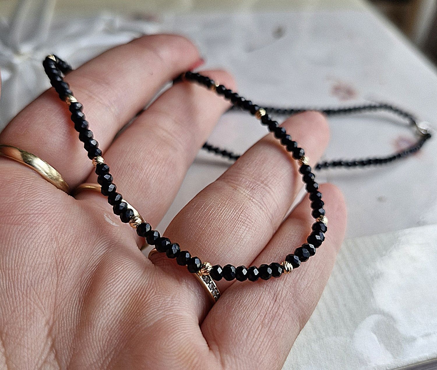 Colier la baza gatului, cu bilute din aur si cristale negre.