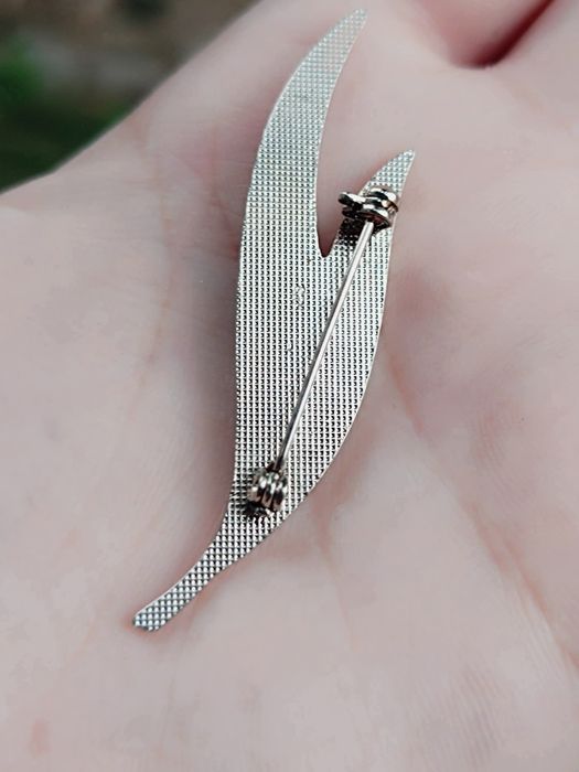 Veche brosa in forma de frunza cu email negru si pietre albe