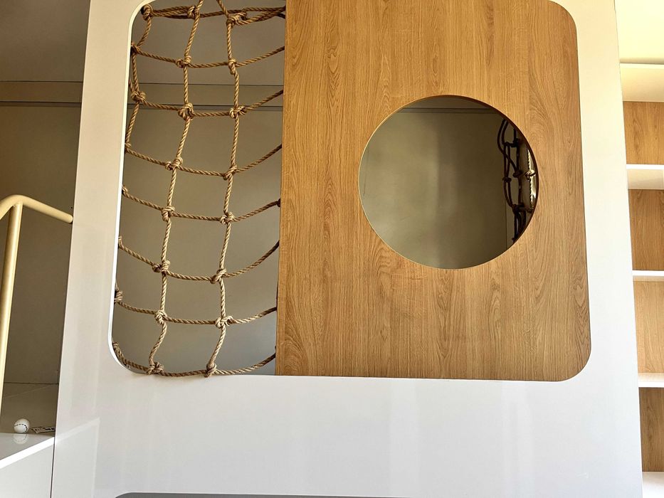 Детски легла на втори етаж със стълба, етажерки и ракли под тях