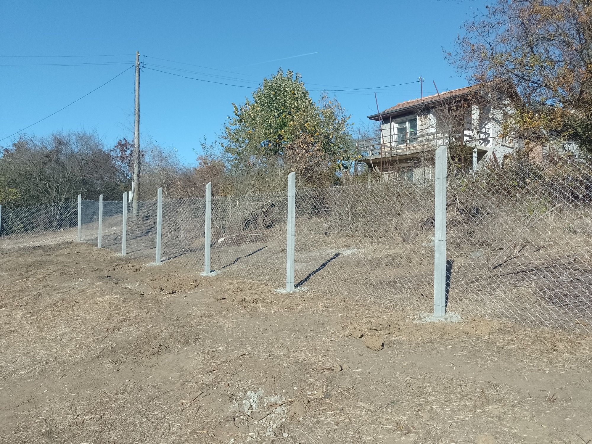 изграждане на огради  ( ограда) с бетонни колове, мрежа, септични ями