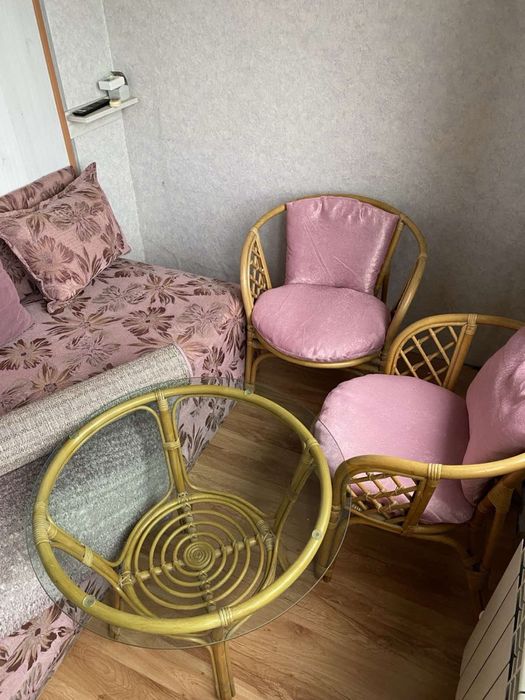 Обзавеждане за стая: диван, ратанови столове с маса и килим.