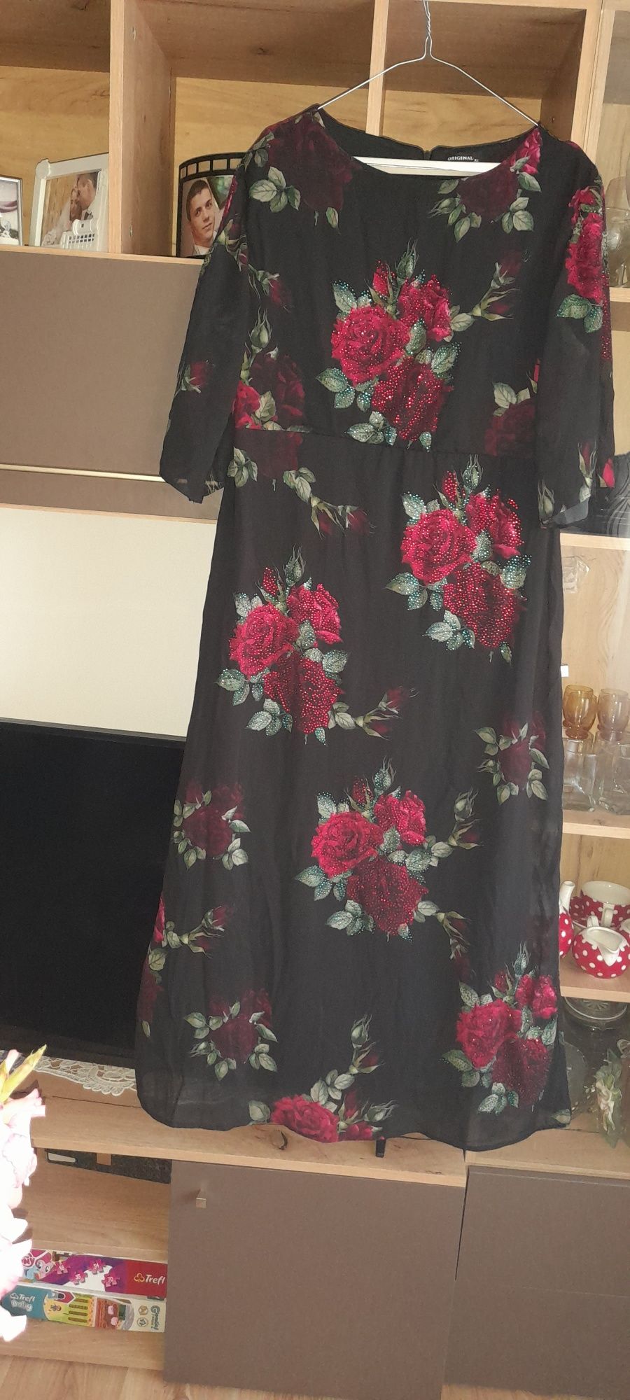 Rochie de seara neagra cu imprimeu de flori cu pietricele este lunga.