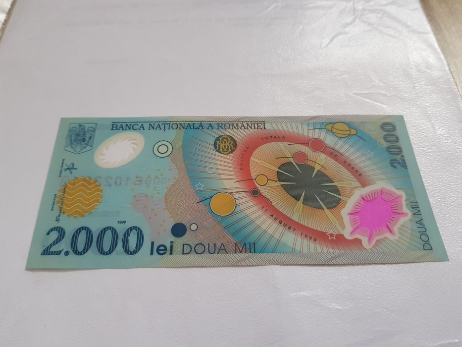 Bancnota 2000 lei cu eclipsa de soare și moneda 500 lei.