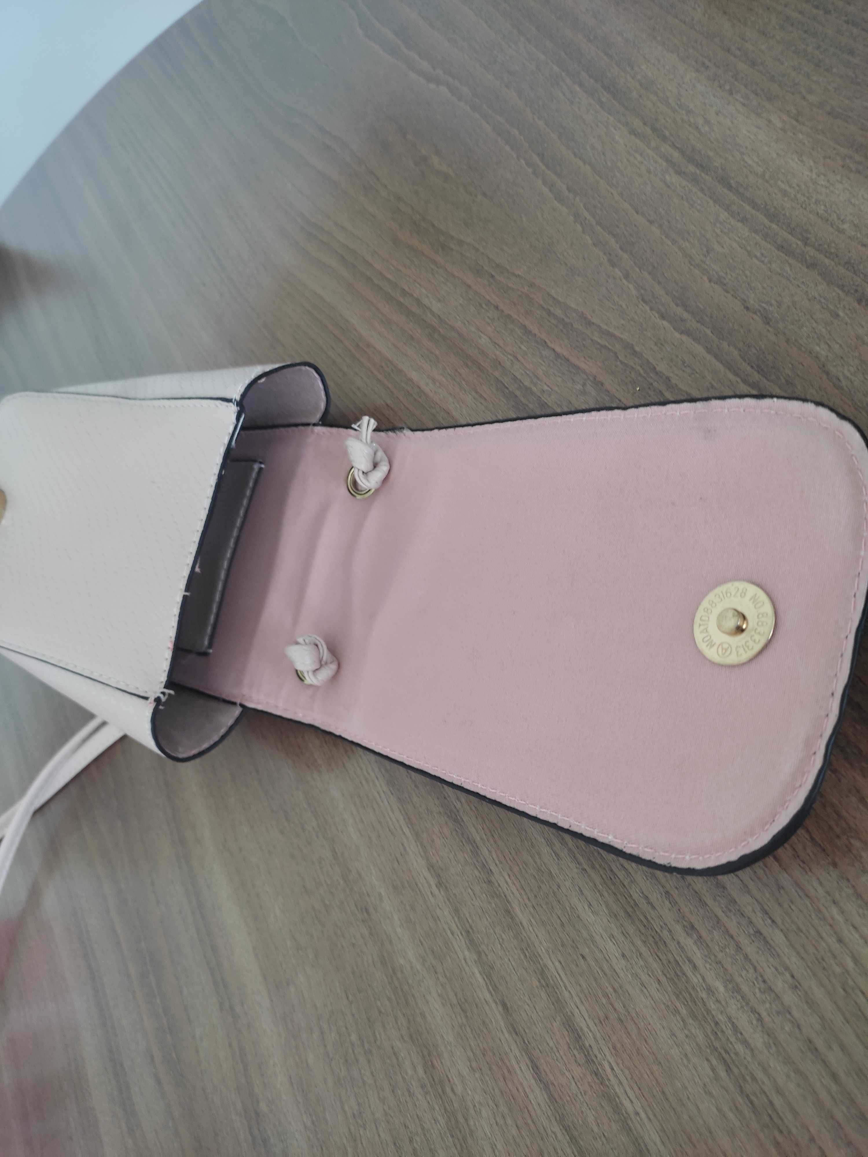 Практична дамска чантичка за телефон и портфейли в бледо розов цвят.