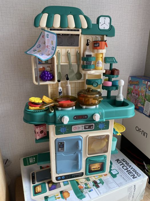 Кухня със светещи котлони, пара и мивка с течаща вода