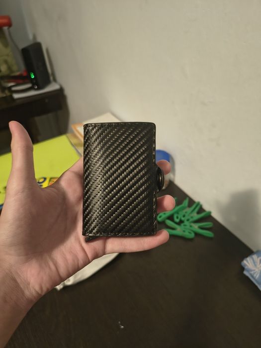portofel negru mic si de fibre de carbon.